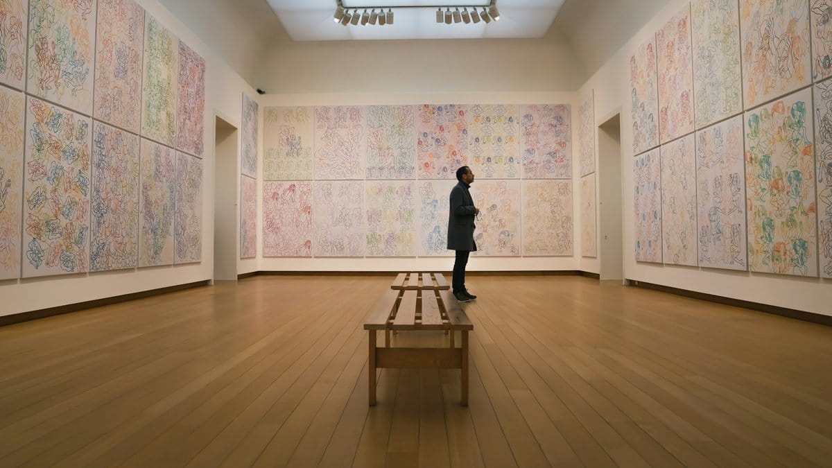 Gallery visitor surrounded by large colorful abstract expressionist paintings