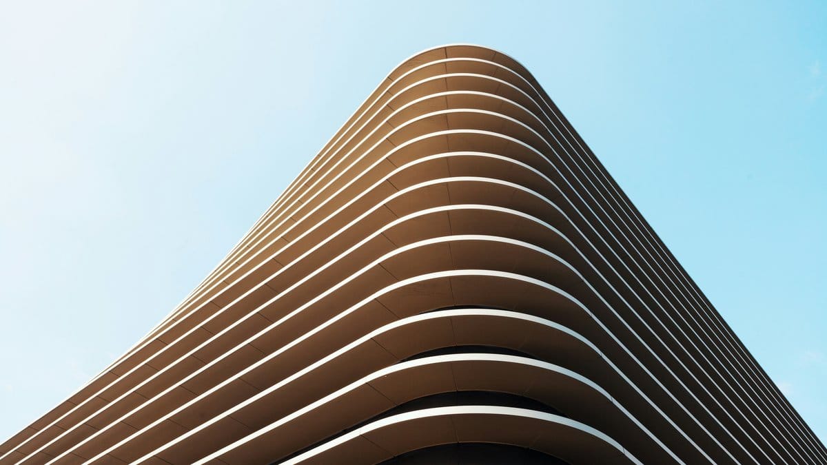Curved ribbed modernist building with horizontal lines against blue sky — Bauhaus architecture