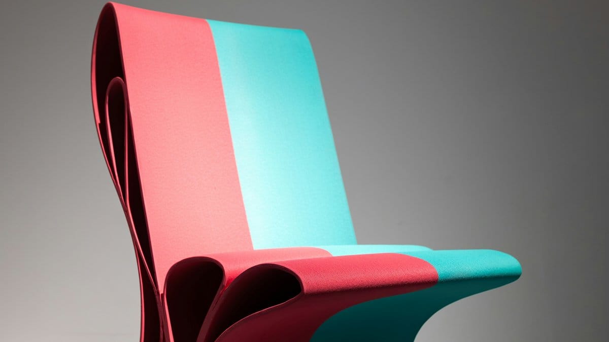 Colorful sculptural folded chair in pink teal and maroon — expressive product design