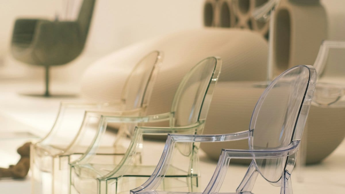 Row of transparent polycarbonate Ghost chairs by Kartell in a modern interior