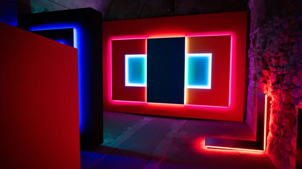 Neon colored rectangular light installation in dark stone room — Rothko color field art