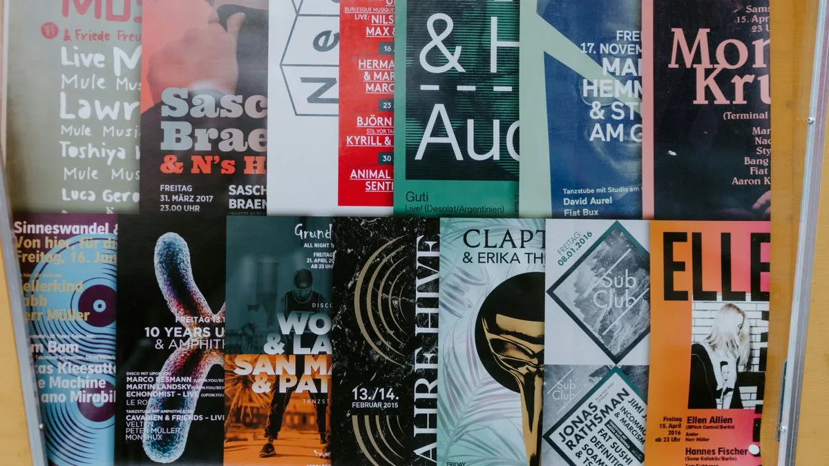Wall covered in colorful event and concert posters — Pop Art graphic design culture