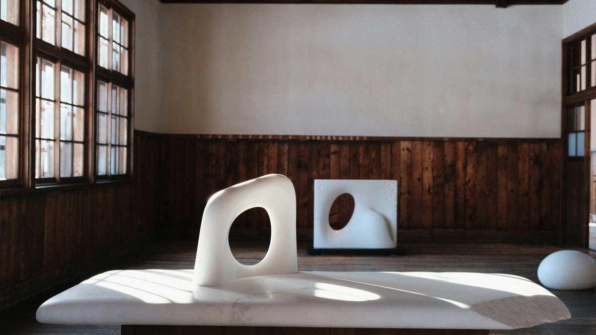 White biomorphic sculptures in a warm wooden studio — modernist design comparison