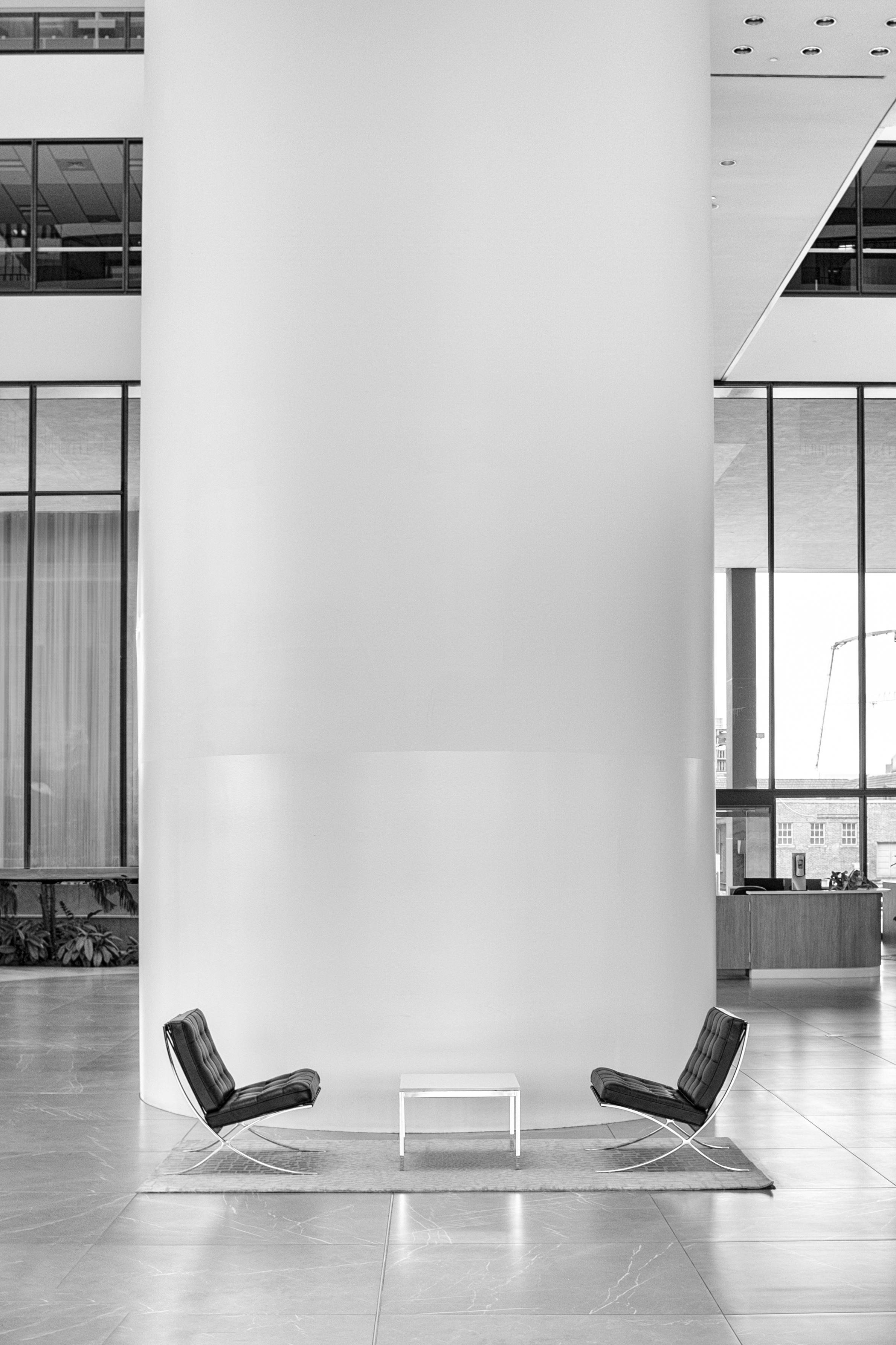 Close-up of the Barcelona Chair showing the X-frame chrome steel structure and hand-stitched tufted leather squares