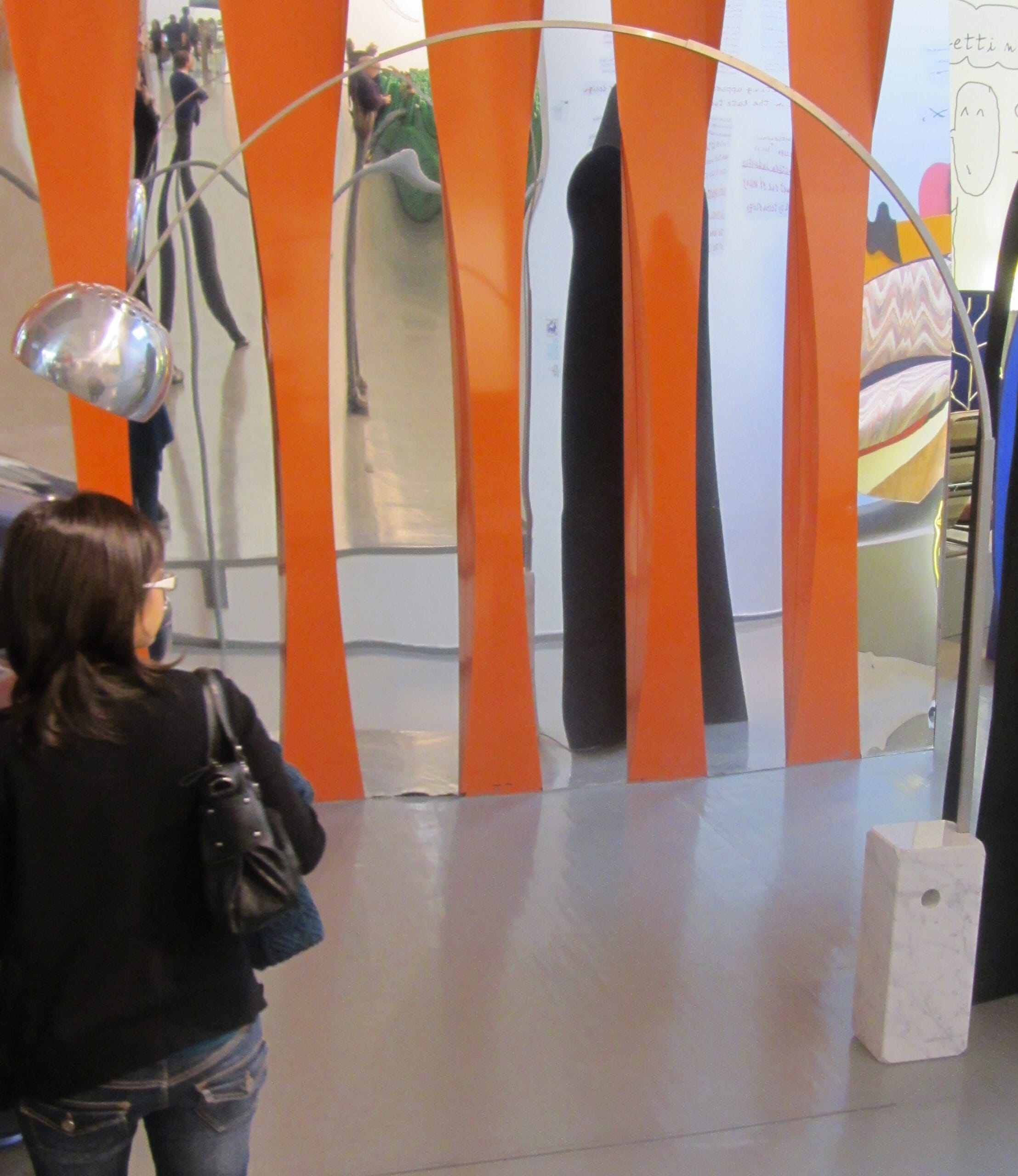 Castiglioni Arco lamp shown in museum display with marble base and arc reaching over a table